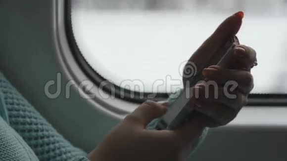 年轻女子坐火车和使用手机女性手从智能手机发送信息女孩的手臂视频的预览图
