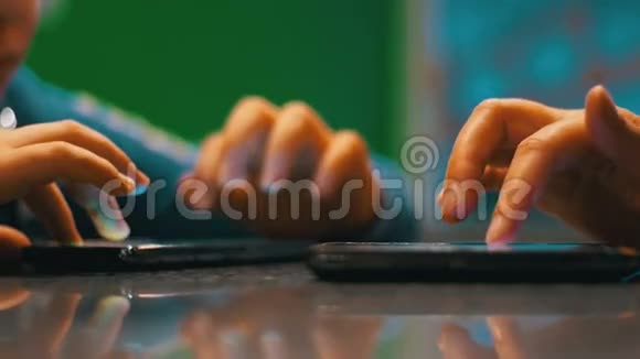 小孩玩电话坐在与人的咖啡馆的桌子上视频的预览图
