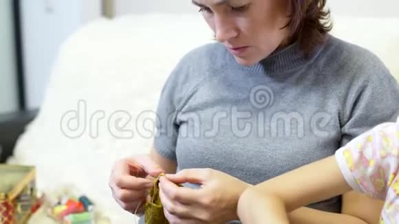 女人用针线缝洋娃娃的衣服视频的预览图