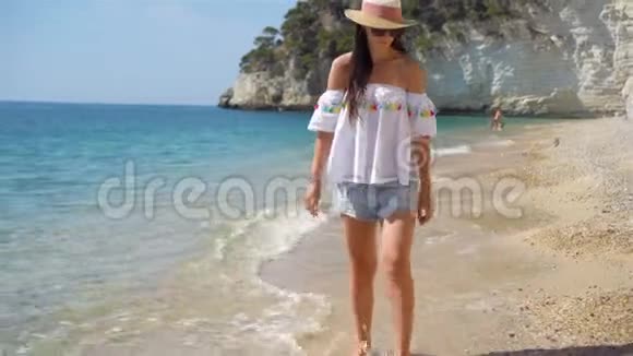 在白沙热带海滩上的年轻美女戴帽子的白人女孩视频的预览图