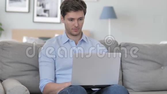 英俊的年轻人在笔记本电脑上庆祝成功视频的预览图