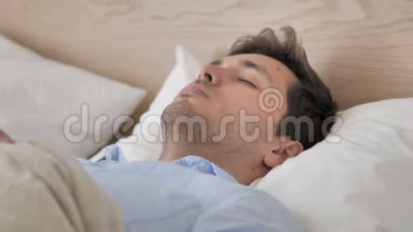 英俊的年轻人睡在床上视频的预览图