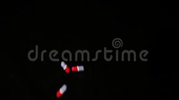 药丸胶囊落在黑色玻璃上视频的预览图