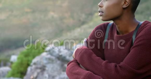 坐在乡村岩石上的女人视频的预览图