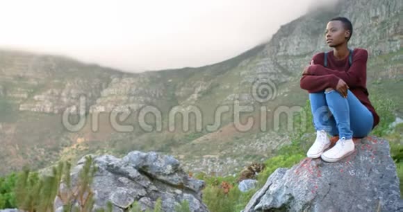 坐在乡村岩石上的女人视频的预览图