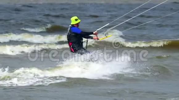 慢动作一位老人在做风筝他在池塘的波浪上美丽地骑着风筝强风视频的预览图