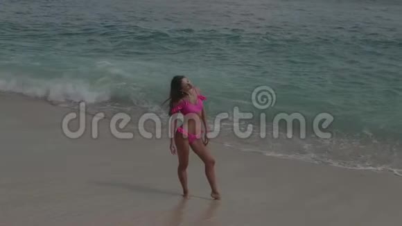 海滩上穿粉色比基尼的美女视频的预览图