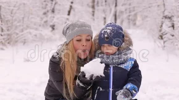 快乐的母亲家庭和孩子在雪地冬季公园玩耍视频的预览图