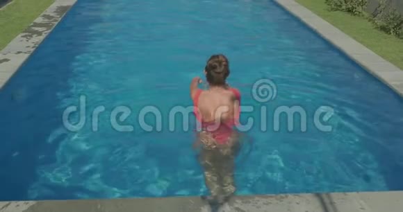 美丽的女人在室外游泳池放松视频的预览图