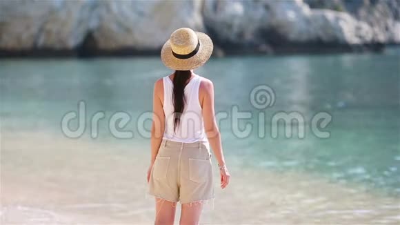 在白沙热带海滩上的年轻美女戴帽子的白人女孩视频的预览图