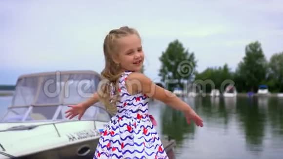 一个可爱的小女孩穿着裙子旋转旋转关闭慢动作小车射击视频的预览图