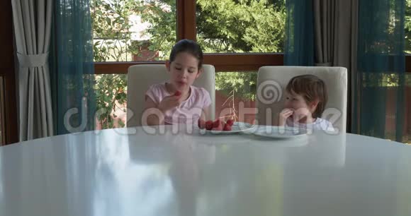 可爱的孩子在家吃新鲜成熟的草莓视频的预览图