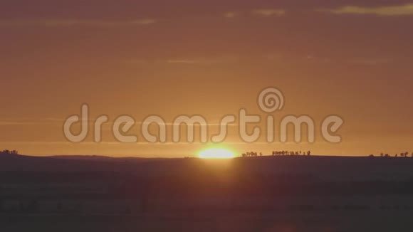 自然日出过田野或草甸明亮的戏剧天空和黑暗的地面风景优美的乡村景观视频的预览图