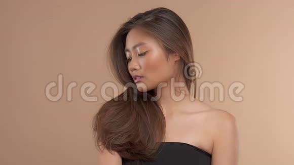 泰裔亚洲模特米色背景自然化妆视频的预览图
