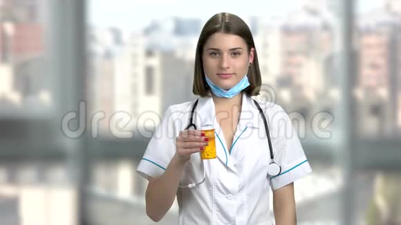 年轻微笑的女医生带着药丸视频的预览图