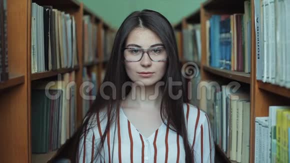 图书馆里年轻漂亮女孩的肖像视频的预览图