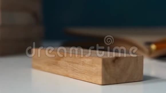 特写手姑娘从木块上取一块积木深色调视频的预览图