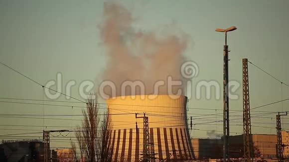 日落时分冒烟的发电厂烟囱视频的预览图