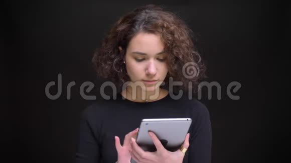 为年轻美丽的白种人女性在平板电脑上打字并向相机显示绿色屏幕的特写肖像视频的预览图
