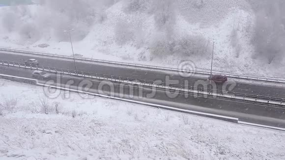 冬天汽车在雪道上行驶雪道上的交通暴风雪视频的预览图