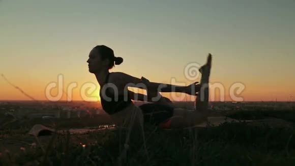 日落时分在公园练习瑜伽的女人视频的预览图