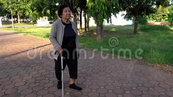 在公园里用手杖走路的老妇人视频的预览图