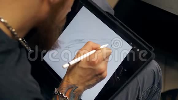 他在平板电脑上画画设计师在PC上使用图形平板电脑视频的预览图
