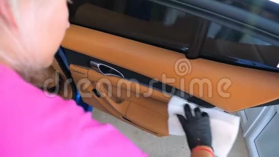 一个女人在洗车场对汽车的各个部分进行全面的干洗视频的预览图