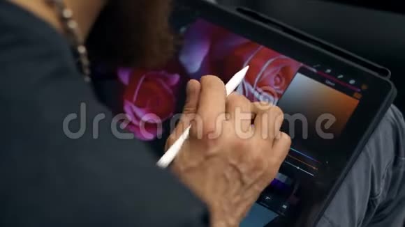 他在平板电脑上画画设计师在PC上使用图形平板电脑视频的预览图