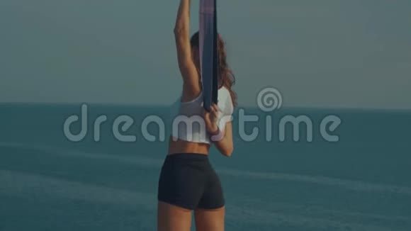 日出时在海边悬崖上运动的女人视频的预览图
