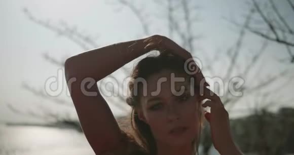 美丽的女人穿着红色的衣服在海边的悬崖上视频的预览图