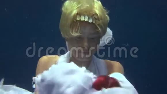 年轻女孩在红海的蓝色背景上模特水下白色天使服装视频的预览图