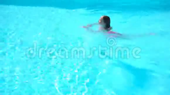 可爱的小女孩在室外游泳池游泳视频的预览图