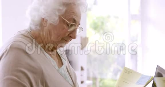 老年妇女阅读文件视频的预览图