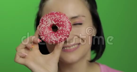 快乐美丽的小女孩摆姿势和玩甜甜圈彩色键视频的预览图