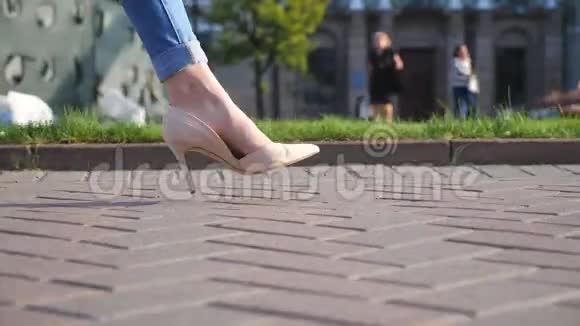 穿着高跟鞋穿过城市街道的女性腿穿高跟鞋的年轻女子在城市里的脚视频的预览图