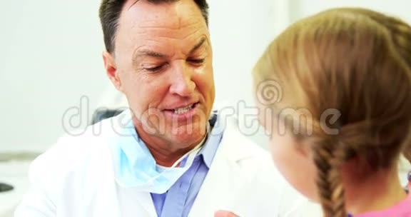 牙医向年轻病人展示如何刷牙视频的预览图
