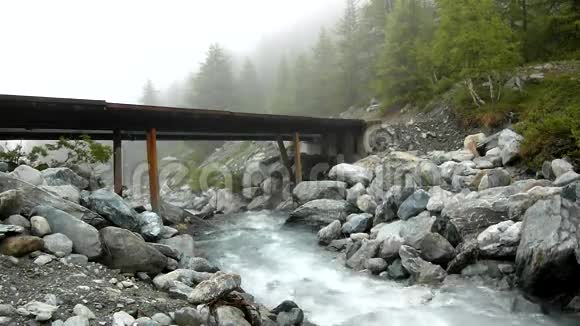 阿尔卑斯山急流上的急流水流过白色的巨石和气泡视频的预览图