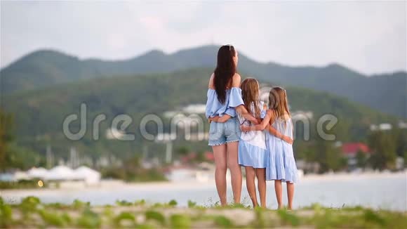 可爱的小女孩和年轻的母亲走在白色的海滩上视频的预览图