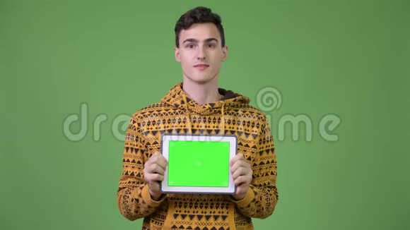 年轻的帅哥展示数码平板电脑看上去很惊讶视频的预览图