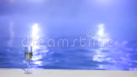 晚上的女人在泳池里喝着热水喝着一杯香槟视频的预览图