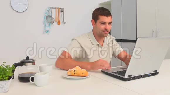 一个人在用笔记本电脑工作时喝着一杯咖啡视频的预览图