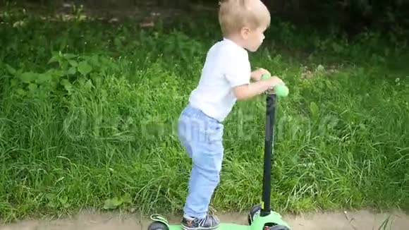 一个快乐的孩子在公园里骑他的滑板车户外乐趣视频的预览图