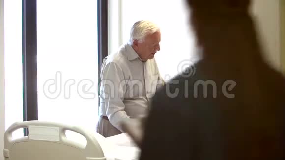 护士在医院的病房里与老夫妇交谈视频的预览图