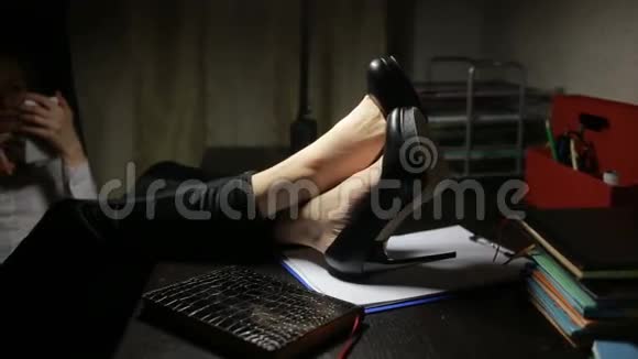 女人坐在办公室的桌子上在智能手机上写信息视频的预览图