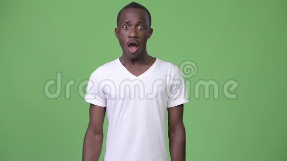 年轻快乐的非洲男人在绿色的背景下举起拳头视频的预览图