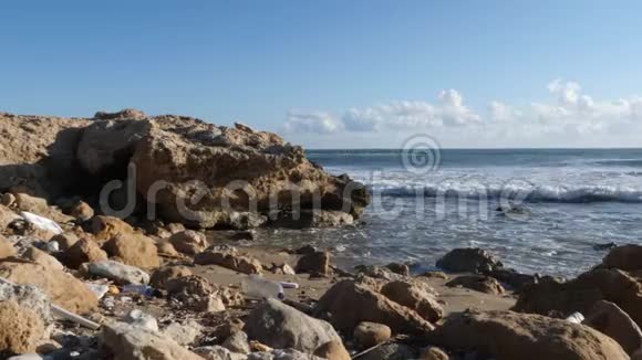 海洋岩石海滩被塑料垃圾污染地球污染慢动作视频的预览图