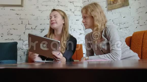 两位在办公室里使用触摸板的商务女性正忙着讨论事情视频的预览图