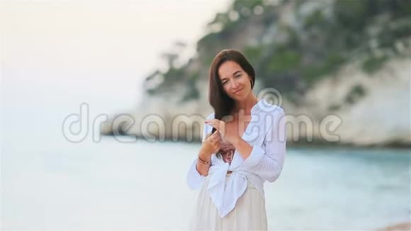 白色热带海滩上的年轻美女视频的预览图