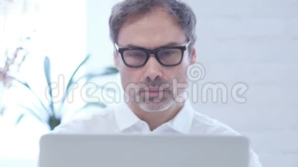 在笔记本电脑上工作时看摄像机的人关门视频的预览图